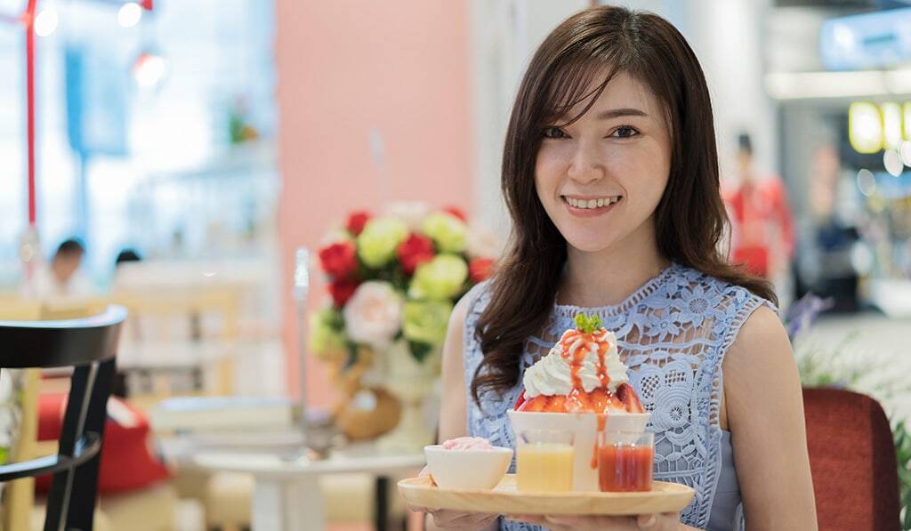 Attractive asian woman holding tray of food
