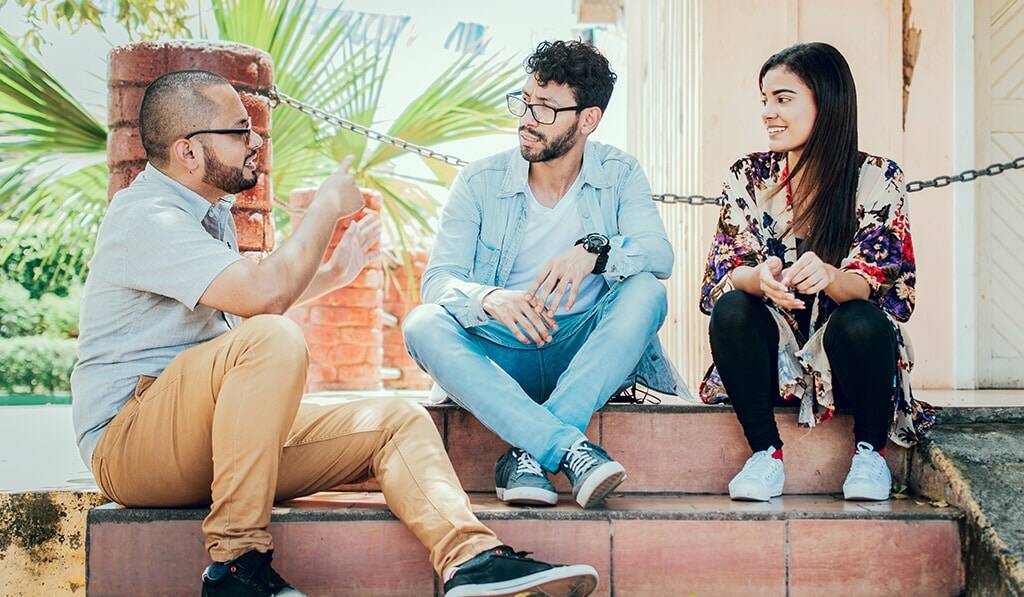 young adults sitting outside talking