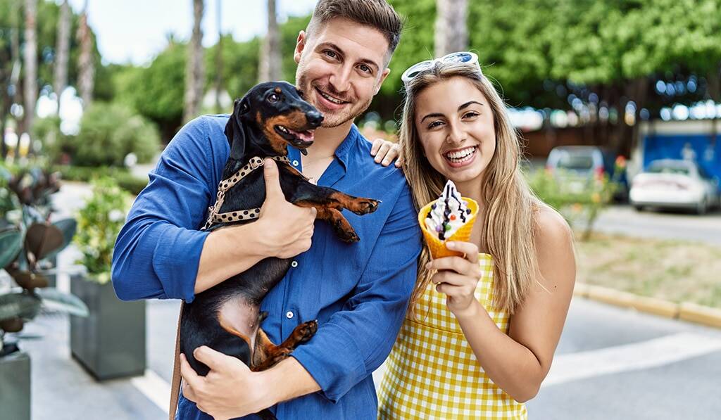 Couple with dog holding ice cream