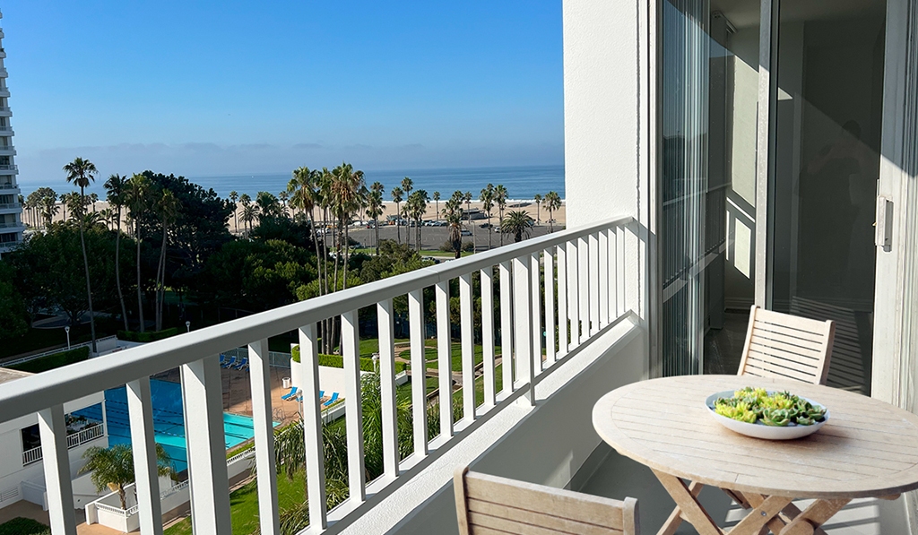 Balcony overlooks the ocean and pool